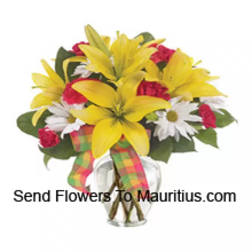 Gigli gialli, garofani rossi e adatti fiori bianchi stagionali disposti splendidamente in un vaso di vetro