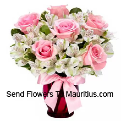 Rose rosa e alstroemeria bianca disposte splendidamente in un vaso di vetro