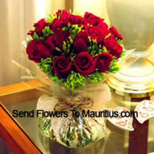 12 rote Rosen mit etwas Farn in einer Vase